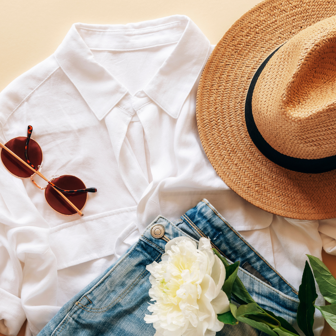 Feminine summer fashion flat lay with white top, jeans, sunglasses, straw hat and white peony flower on beige background