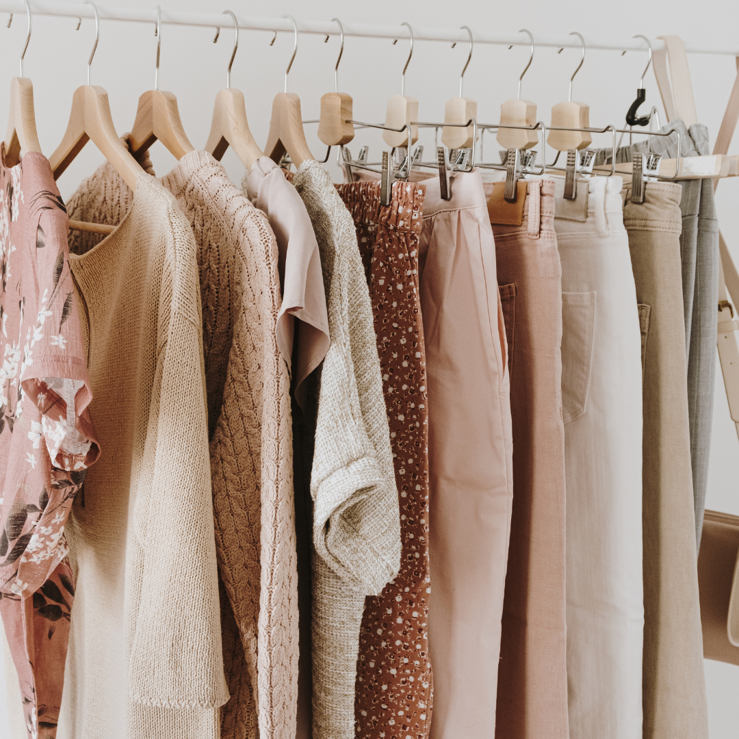 Capsule wardrobe concept with stylish neutral clothes in a hanger