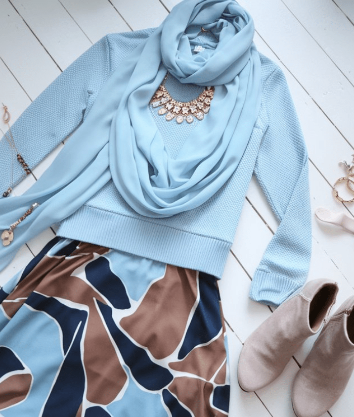 A flat lay of modest clothes and accessories in pale blue and brown