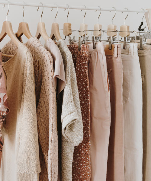 Capsule wardrobe concept with stylish neutral clothes in a hanger